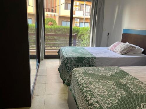 2 bedden in een hotelkamer met een raam bij Marsilia blue bay in Ain Sokhna