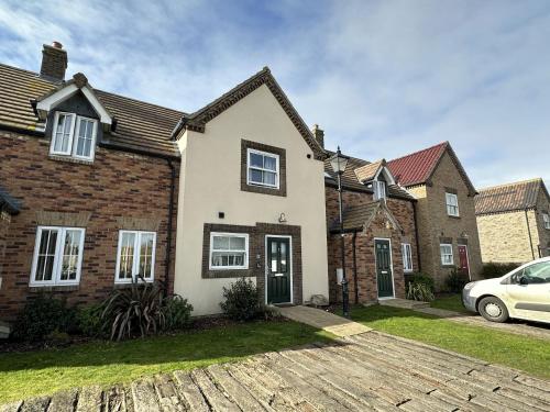 a house with a car parked in front of it at A Wave From It All - Part of the The Bay Filey Holiday Village with pool, gym and direct beach access, pub, restaurant, tennis and meadows walks in Filey