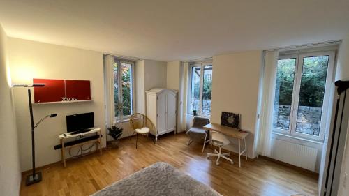 an empty living room with a television and a desk at Eigenes Studio (Apartment) in Biel