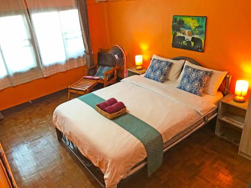 ein Schlafzimmer mit einem großen Bett mit orangefarbenen Wänden in der Unterkunft Meechok Home in Chiang Mai