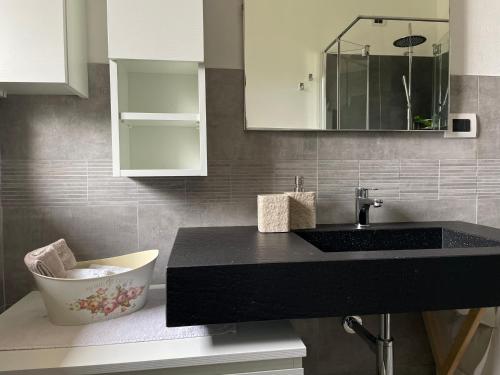 een badkamer met een zwart aanrecht en een wastafel bij B&B Carmen in San Giovanni Bianco