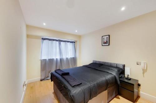 a bedroom with a bed and a window at Apartment in the heart of London in London