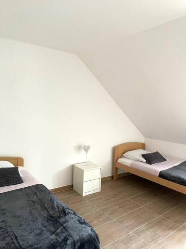 1 Schlafzimmer mit 2 Betten und einer weißen Wand in der Unterkunft appartement - châtenois in Châtenois