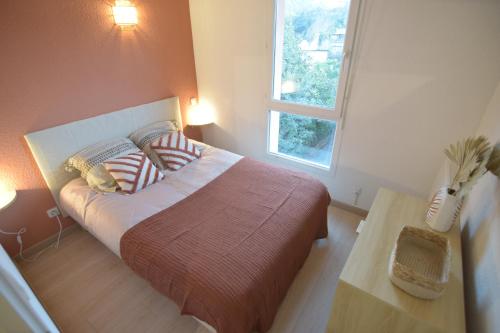 - une chambre avec un grand lit et une fenêtre dans l'établissement [Le Bohème] T2-Wifi-Calme-Parking, à Lourdes