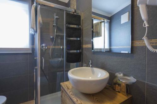 bagno con lavandino e doccia in vetro di Residence Aspen ad Arabba