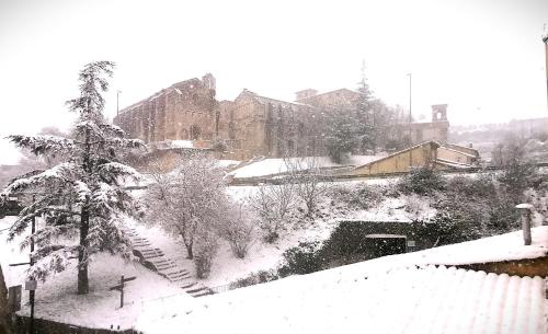 a snow covered city with a building and a tree at Apartamento El Mirador de la Rua in Estella