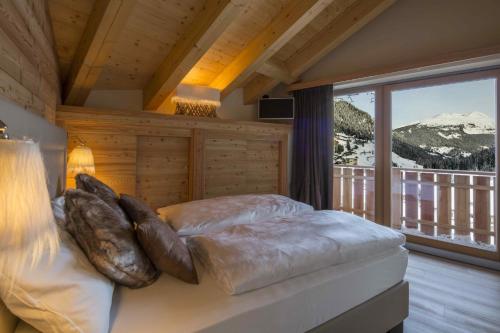 a bedroom with a bed with a view of a mountain at Residence Aspen in Arabba