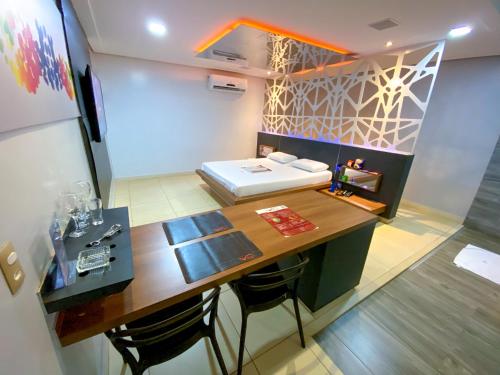 Habitación con escritorio, cama y mesa. en Rodotel Vênus Prime, en Rio Verde