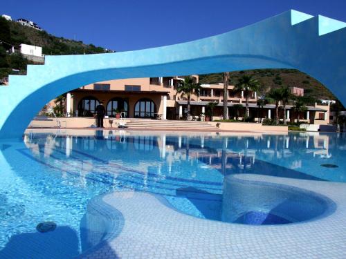 a swimming pool with a blue arch over it at Hotel Aktea in Lipari