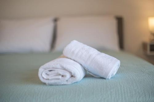 a rolled up white towel sitting on a bed at Kos Helios House in Psalidi