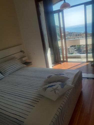 a bedroom with a large bed with a large window at Bressa de Ma affittacamere, room & breakfast in Pietra Ligure
