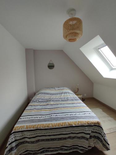une chambre avec un lit avec une couverture dessus dans l'établissement La Petite Chaume, à Châteauroux