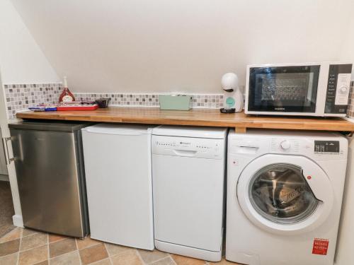 a kitchen with a microwave and a washer and dryer at No 51 Valley Lodges in Callington