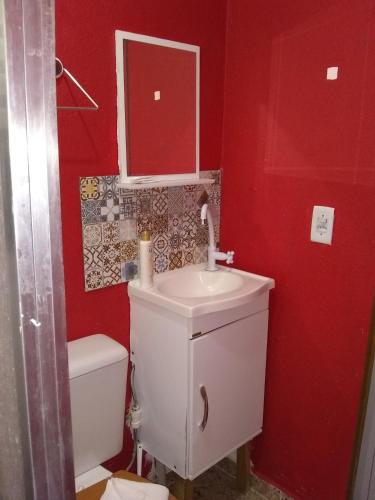 Baño rojo con lavabo y aseo en Casa da Dine-sem café-suite-quadruplo fundos, en Campos do Jordão