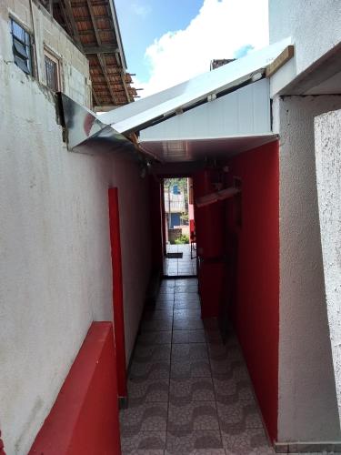 un pasillo que conduce a un edificio con una puerta roja en Casa da Dine-sem café-suite-quadruplo fundos, en Campos do Jordão