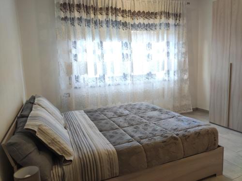 una camera con un letto di fronte a una finestra di Bidda Mores Appartamenti- Il Cacciatore a Capoterra