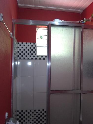 y baño con ducha y puerta de cristal. en Casa da Dine-sem café-suite-quadruplo fundos, en Campos do Jordão