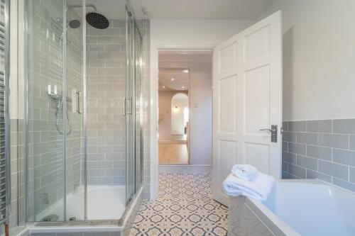 a bathroom with a shower and a tub and a sink at Southview Stays - Three bedroom House in Chester