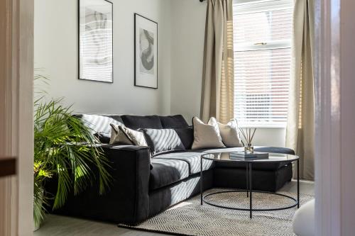 a living room with a black couch and a table at Southview Stays - Three bedroom House in Chester