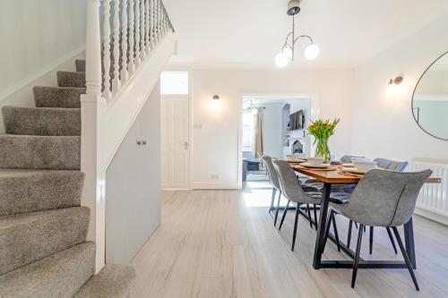 a dining room with a table and chairs and a staircase at Southview Stays - Three bedroom House in Chester
