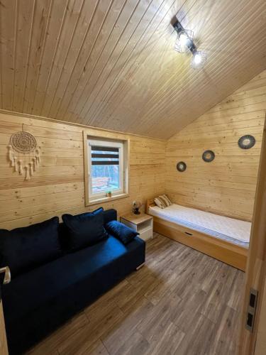 sala de estar con sofá y cama en Domki u Tosiek, en Stegna