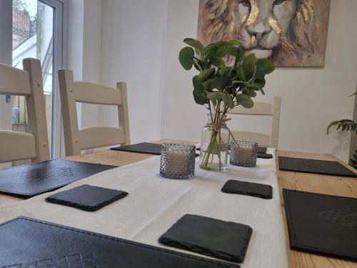 a dining room table with a vase of plants on it at Hill View in Abertillery