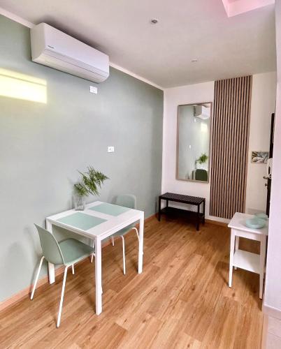 una sala da pranzo con tavolo e sedie bianchi di La Casina Verde - Appartamento Mansardato a Livorno