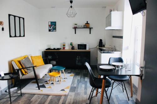 un salon avec une table et des chaises et une cuisine dans l'établissement Appartement de charme 1er etage, à Saint-Samson-sur-Rance