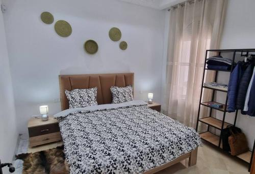 1 dormitorio con 1 cama con edredón blanco y negro en Villa des Lotophages, en Djerba