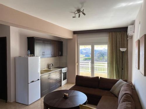 uma sala de estar com um sofá e uma cozinha em Raise Mirivili Serviced Apartment em Alexandroúpolis