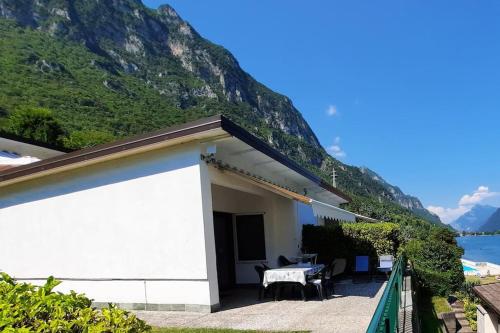 a white house with a table in front of a mountain at Holiday Apartment Anna 63 Idro in Anfo