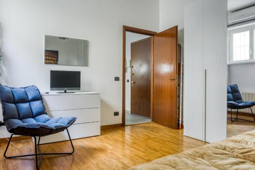 ローマにあるTIBURTINA Apartmentのリビングルーム(ソファ、テレビ、椅子付)