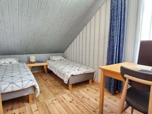 ein Zimmer mit zwei Betten und einem Schreibtisch und einem Tisch in der Unterkunft Jannseni House in Pärnu