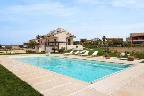 a swimming pool in front of a house at Villa Paradiso with private pool, BBQ area, huge garden and free parking in Modica