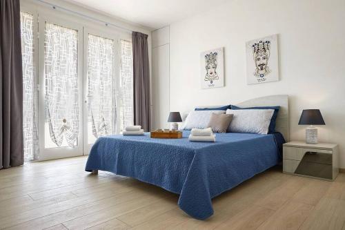 una camera con un letto blu e una grande finestra di Villa Paradiso with pool, fireplace & barbeque a Modica