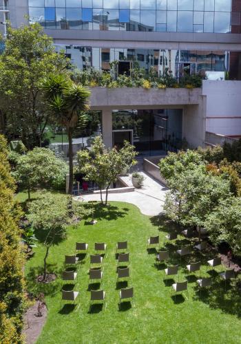 a group of chairs on the grass in front of a building at GO Quito Hotel in Quito
