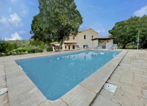 - une piscine en face d'une maison dans l'établissement Alojamiento Can Alegre, à El Perelló
