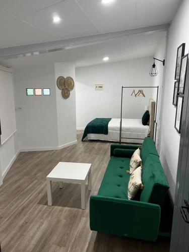 a living room with a green couch and a bed at Apartamento en Cieza AM in Cieza