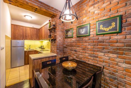 eine Backsteinwand in einer Küche mit einem Tisch in der Unterkunft Ohrid Boutique Apartments in Ohrid