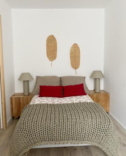 1 dormitorio con 1 cama con almohadas rojas y 2 lámparas en Apartamento C/ Concepción Arenal, en Ferrol