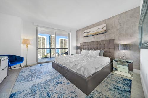a bedroom with a large bed and a large window at Beachwalk Resort - OCEAN VIEW WRAP AROUND BALCONY 3BD - 3BR CONDO in Hallandale Beach