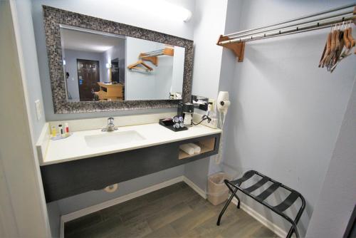 a bathroom with a sink and a mirror at Columbus Inn and Suites in Columbus