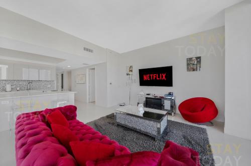a living room with a red couch and a tv at BeachWalk Resort PH - DREAM-SKY MANSION 3DBR and 3BA LUXURY PENTHOUSE in Hallandale Beach