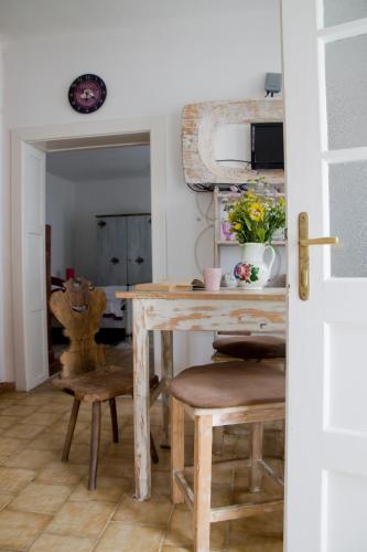 a dining room with a wooden table and chairs at Nótás Tücsök Vendégház in Agyagosszergény