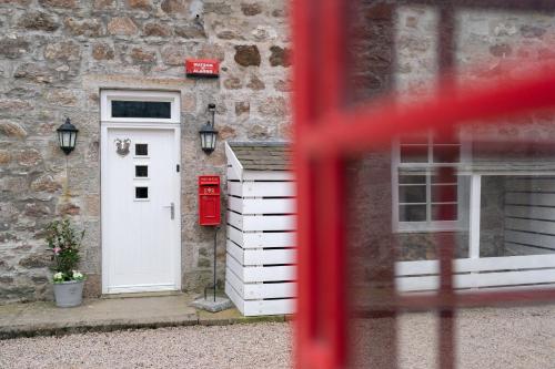 a house with a white door and a red mailbox at Ranch House Cottage, Pet Friendly Stay, Inverurie in Thainstone