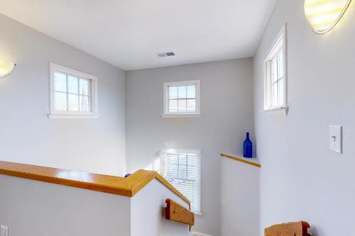 a room with white walls and a staircase with windows at Turtle #21B-CAC in Buxton