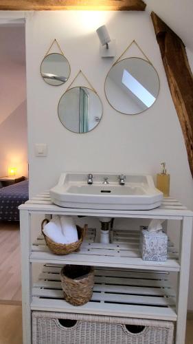 une salle de bain avec un lavabo et des miroirs au mur dans l'établissement Le Petit Lavoir - Maison Cosy à Mayet, à Mayet