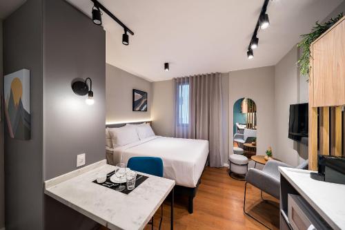 une chambre d'hôtel avec un lit et une table dans l'établissement Xtay Princess Curitiba, à Curitiba