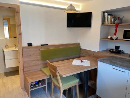 una pequeña cocina con mesa de madera y sillas en Neuhäusl-Hof, en San Genesio Atesino