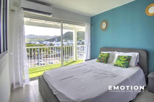 - une chambre avec un lit et une grande fenêtre dans l'établissement Cozy Yacht Club, à Marigot